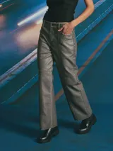 Pantalón de corte recto y tiro medio, confeccionado en material con acabado encerado color gris oscuro. Presenta costuras decorativas verticales a lo largo de las piernas y costura horizontal a la altura de la rodilla, con bolsillos laterales y cierre frontal.
