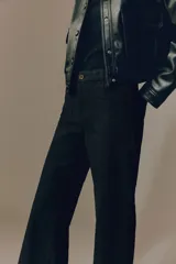 Pantalón amplio de sarga de algodón negro, con perneras rectas, bolsillos delanteros de parche y cierre frontal con botón.