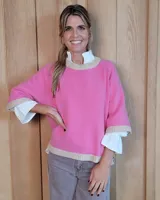 Buzo de lana lambswool color rosa, con cuello redondo, puños y ruedo en tejido acanalado de color beige. Presenta un diseño holgado de manga tres cuartos.