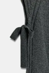 Chaleco de punto confeccionado en mezcla de lana, con cuello subido, diseño sin mangas y aberturas laterales con detalle de lazos.