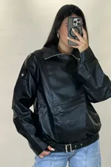 Chaqueta de ecocuero negro con diseño oversize, cuello solapa, cierre frontal y cinturón ajustable en el ruedo.