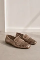Mocasines chatos de cuero vacuno en color celeste, con diseño calado en toda la superficie y detalle de tira lisa en el empeine. Poseen suela plana y taco bajo de goma.