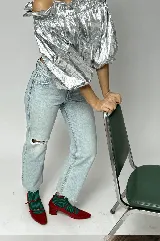 Blusa de poliéster plateado metalizado, con diseño off-shoulder, mangas abullonadas y terminaciones con elástico fruncido.