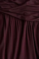 Pantalón globo color bordó, de corte holgado en punto de viscosa, con cintura elástica ancha fruncida y piernas fruncidas con elástico en los tobillos.