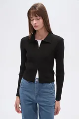 Saco de tejido de punto acanalado, color negro, con cuello tipo camisa y cierre frontal completo. De corte ajustado al cuerpo y manga larga.