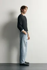 Pantalón jeans de corte recto, color celeste claro con efecto lavado, de cinco bolsillos y tiro medio.