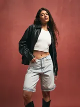 Short tipo bermuda de jean en color azul claro con lavado ácido, de corte holgado y largo hasta la rodilla con ruedo doblado.
