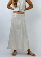 Pollera midi de lino con diseño de paneles verticales en tonos beige y gris, con costuras decorativas a la vista.