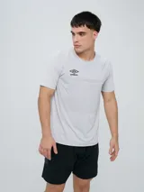 Remera deportiva Umbro modelo Axis, de manga corta, color gris claro con textura perforada transpirable y logo negro de la marca en el pecho.