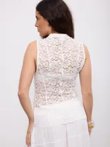 Top de encaje color blanco, sin mangas, con cuello mao y cierre frontal con nudos y presillas.