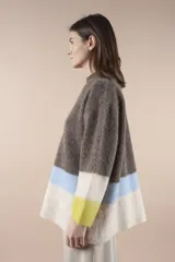 Sweater de lana multicolor con cuello redondo y mangas largas. Diseño con bloques de color en marrón, amarillo, celeste y blanco.