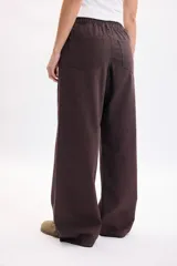 Pantalón de jean marrón de corte recto y tiro medio, con lazo ajustable en la cintura.