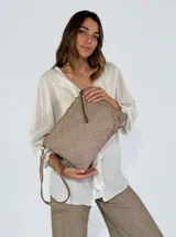 Cartera tipo sobre color beige con diseño tejido, cierre superior con cordón de cuero y correa de cuero extraíble.