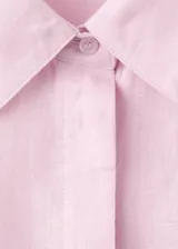 Camisa de lino color rosado, con diseño recto, cuello camisero, manga larga con puños abotonados y cierre frontal de botones.