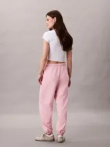 Jogger de felpa Calvin Klein color rosado, de corte tapered con cintura elástica, bolsillos laterales y bajos de canalé. Cuenta con un pequeño monograma estampado en la pierna.