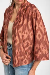 Kimono de viscosa color cobre con estampado geométrico abstracto en tonos marrones y destellos metalizados, de mangas 3/4 y diseño fluido y abierto.