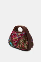 Bolso tipo caja con asa de mano rígida de madera, confeccionado con paneles de tela bordados con motivos florales, paisley y detalles en hilo metalizado.