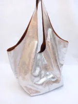 Bolso plateado tipo boho realizado en napa softy texturada, con asa doble reforzada para llevar al hombro y bolsillo interior.