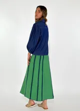 Pollera larga de jean azul con rayas verticales verdes.