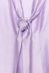 Camisa de ZARA Woman Collection confeccionada en hilatura con mezcla de lyocell, de color blanco marfil. Presenta cuello redondo, escote en V con lazadas en el mismo tejido, manga larga con puño y bajo recto.
