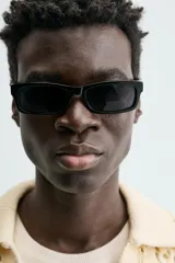 Polo de punto con estructura calada en color beige, confeccionado en algodón. Presenta un calce relajado, manga corta, cuello solapa con abertura frontal y terminaciones acanaladas.