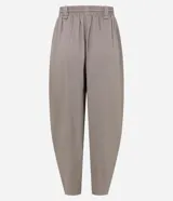 Pantalón carrot de viscolino color marrón, de corte amplio en la cadera y ajustado hacia los tobillos. Cuenta con cintura elástica en la parte posterior, lazo frontal para ajuste y caída liviana.