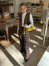 Pantalón de corte ancho y tiro alto con estampado a cuadros en tonos marrón y negro.