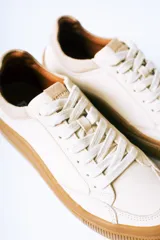 Championes urbanos de gamuza color bordó con suela de goma color caramelo y cordones blancos.