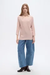 Sweater de tejido acrílico de corte holgado, color rosado, con cuello redondo y mangas 3/4.