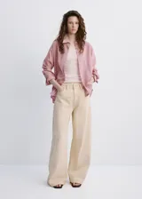 Camisa de lyocell color rosado con diseño a rayas sutiles, de corte recto, con cuello camisero, manga larga y cierre frontal de botones.