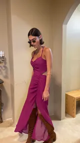 Vestido midi color uva con escote corazón, tirantes finos y aberturas laterales en la cintura. Presenta un diseño con frunces frontales y una falda con tajo lateral.