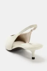 Zapato destalonado de piel en color blanco roto, con tacón kitten fino, puntera fina y tira elástica trasera.