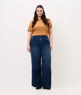 Pantalón wide leg de jean color azul oscuro con diseño de tiro alto, pernera amplia y recta, bolsillos estilo five pockets y cierre frontal con botón y cremallera.