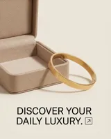 Pulsera tipo esclava rígida de acero con baño de oro, con diseño grabado de patrón geométrico de rombos en toda su superficie.
