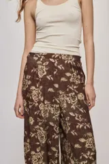 Pantalón de tiro alto y silueta amplia con estampado floral, pinzas en el frente, volumen relajado y terminación elastizada en los tobillos.