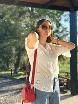 Bandolera roja de cuero con forro de tela, con bolsillo interior y exterior.