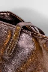 Cartera tipo tote bag de color negro con acabado brillante y efecto arrugado, cuenta con doble asa de hombro.