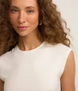 Blusa blanca sin mangas, confeccionada en tejido rib con textura de rayas.