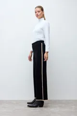 Pantalón tejido de corte recto y tiro alto, color negro con detalles de líneas laterales en tono beige. Posee cintura elástica para mayor comodidad.