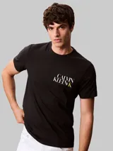 Remera de algodón negro con cuello redondo y mangas cortas. Presenta un diseño gráfico con el logo de la marca estampado en el pecho en color blanco y amarillo.
