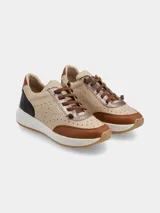Championes de estilo urbano con diseño multicolor en tonos beige, marrón y negro. Presentan perforaciones decorativas en los laterales, cordones marrones y una suela de goma con efecto moteado.