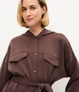 Campera deportiva Get Over de color negro, confeccionada en mezcla de poliéster, modal y elastano. Presenta diseño utilitario con capucha, cierre frontal de botones, bolsillos con solapa en el pecho, mangas largas y lazo ajustable en la cintura.