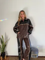 Pantalón de cuero sintético marrón con detalles en negro y vivos color crema.