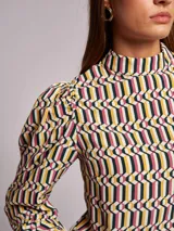 Blusa de viscosa con estampado geométrico multicolor, cuello subido y manga larga abullonada con frunces en los hombros.