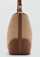 Bolso tipo bucket de canvas y efecto piel, con base, asas y detalles en marrón. Cuenta con una trabilla frontal con candado metálico dorado y cierre magnético.