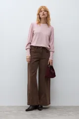Remera de punto color rosa melange, con cuello redondo y mangas largas con diseño abullonado en los hombros y puños ajustados.