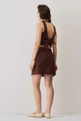 Falda cruzada tipo wrap color beige, de lino, con diseño asimétrico y bordes deshilachados. Cuenta con cierre de botón en la cintura.