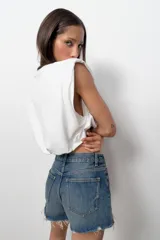 Top de algodón con cuello redondo, diseño sin mangas con hombreras marcadas y detalle de pliegues. Presenta un bajo acabado tipo globo con elástico.