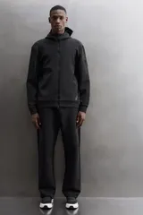 Campera canguro de Zara Athleticz, modelo relaxed fit, confeccionada en tejido técnico compacto elástico con mezcla de algodón en color azul marino. Cuenta con cuello subido con capucha, manga larga con bolsillo lateral con cierre, bolsillos frontales con cierre y acabado termofijado, cierre frontal de doble dirección y logo estampado en el bajo.