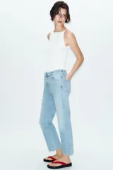 Jeans de tiro alto con corte mini flare y largo tobillero. Presentan diseño de cinco bolsillos, pernera estrecha con acabado evasé y cierre frontal con cremallera y botón.